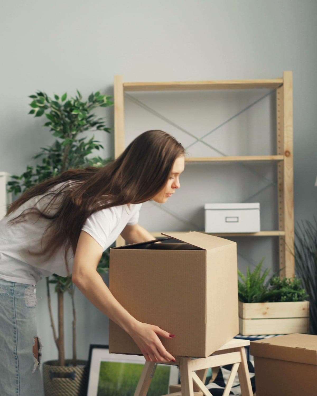 A person packing boxes in a bright living room